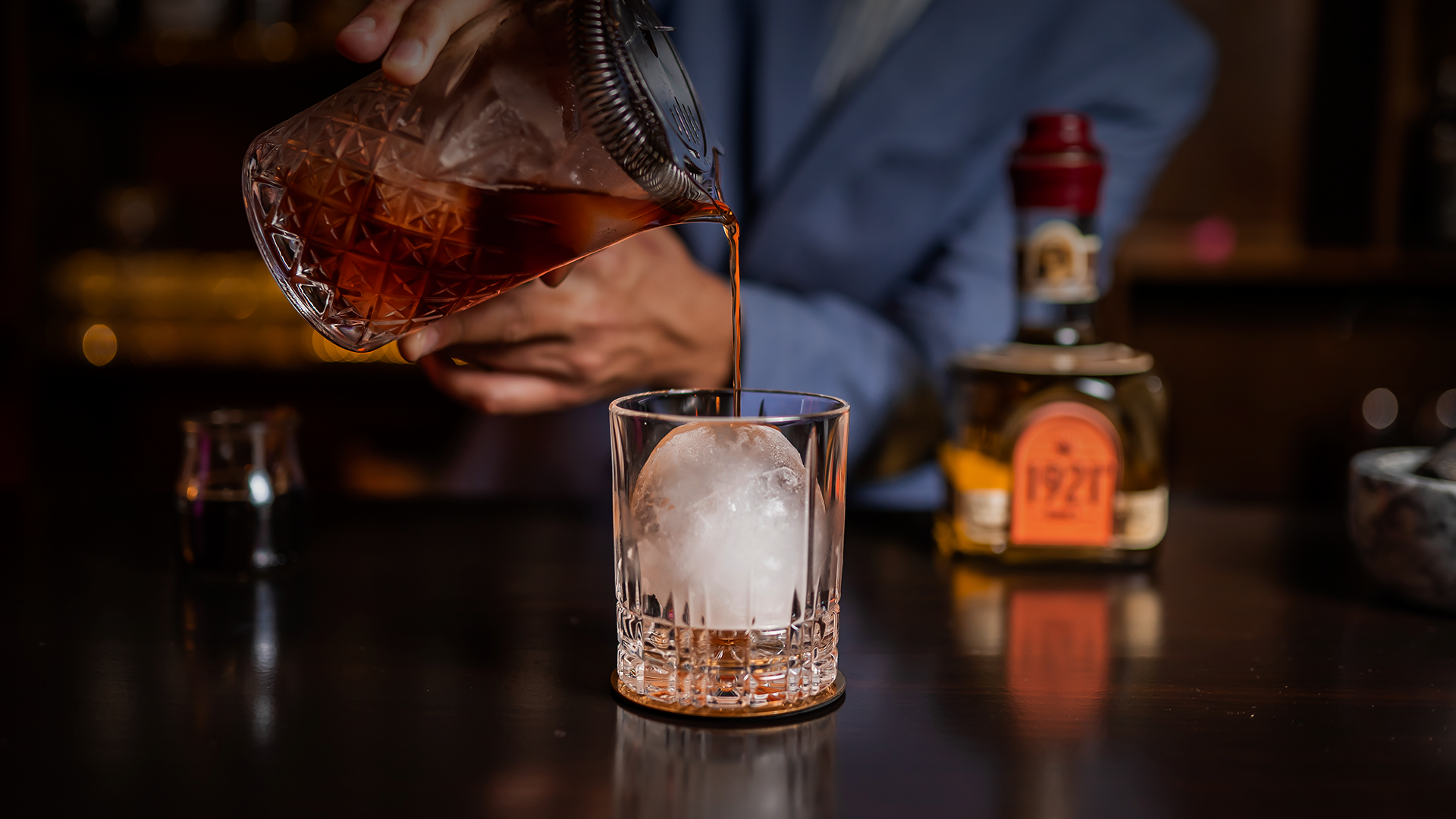 Pouring 1921 Tequila Añejo into the mixing glass